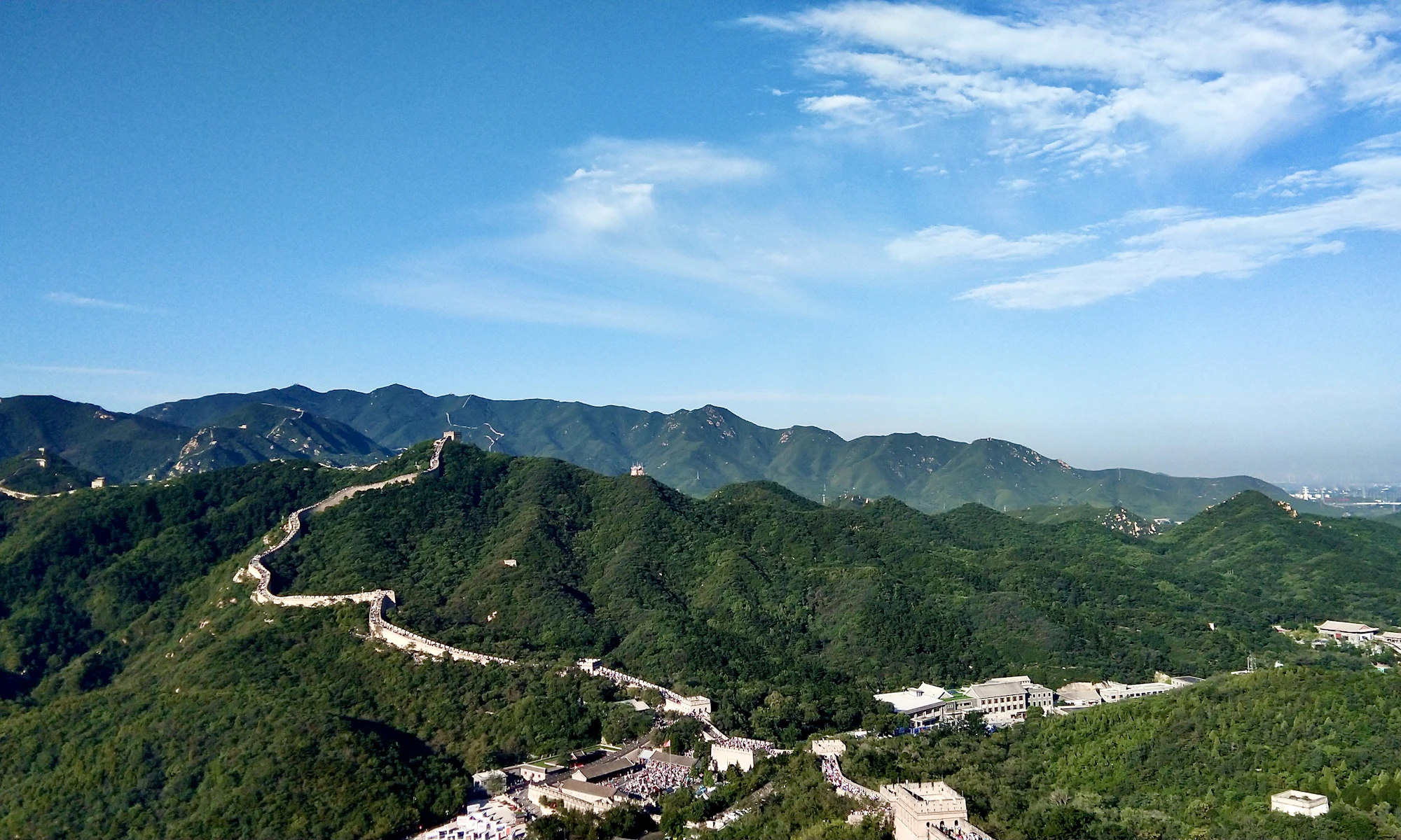 The Great Wall of China crossing green mountain ridges
